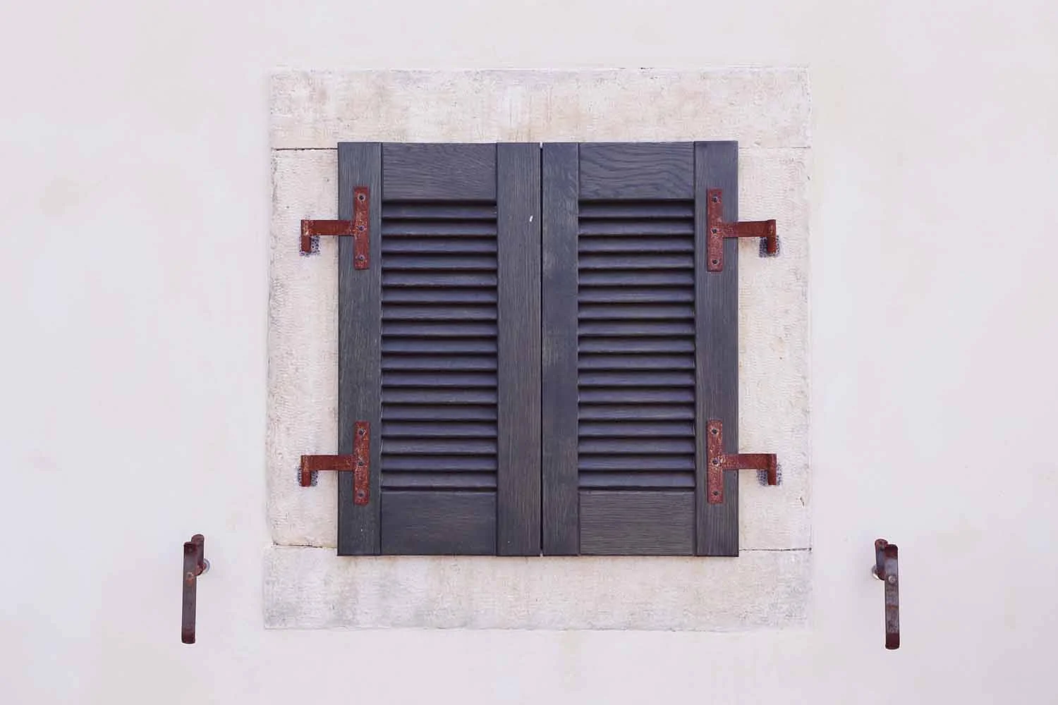 Hand-stained timber shutters with iron fittings