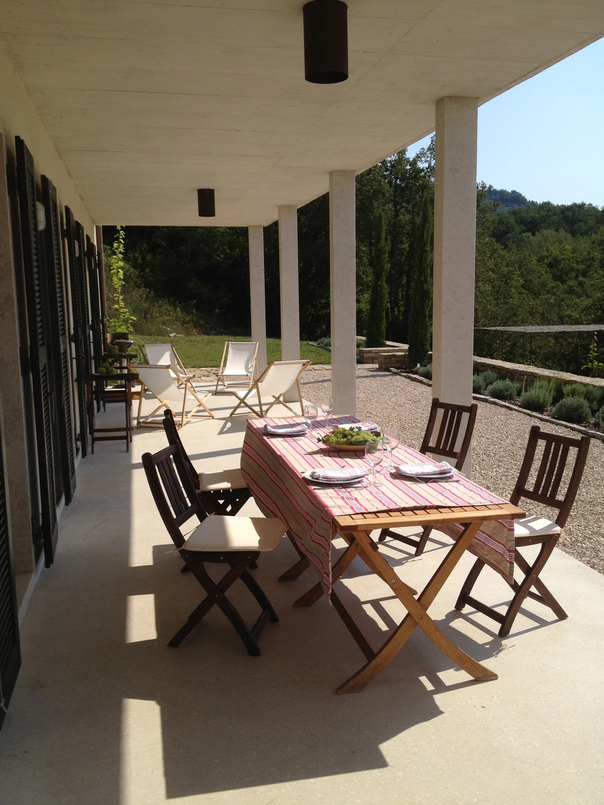 Sunny terrace in front of kitchen with table and chairs