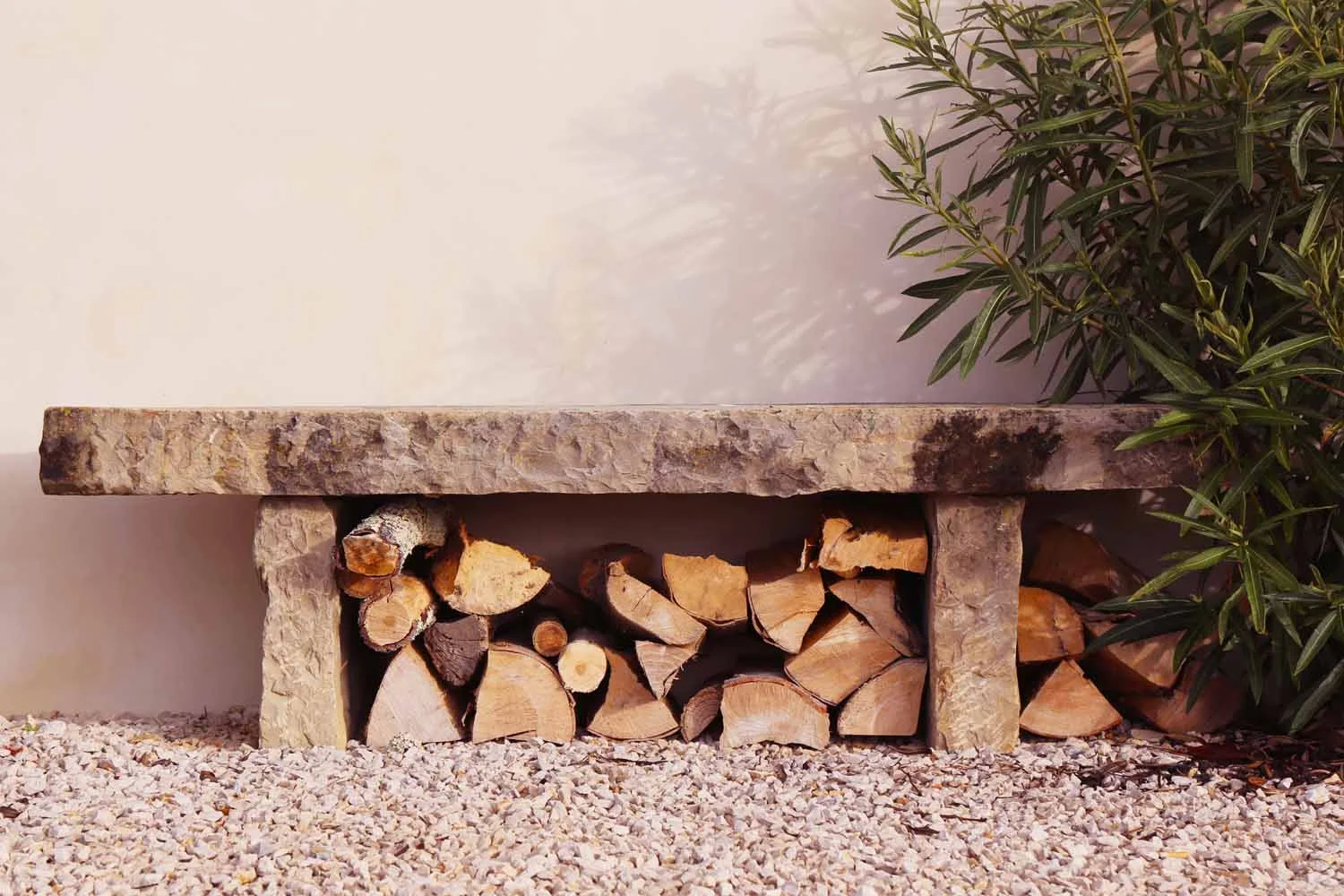 Stone bench with stacked firewood