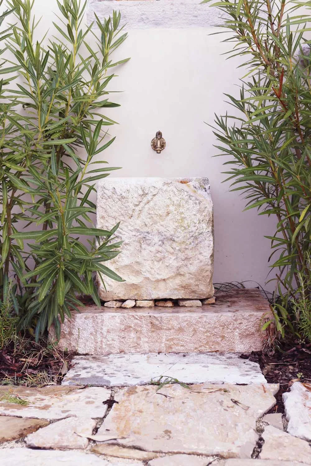 Stone fountain with oleanders in courtyard