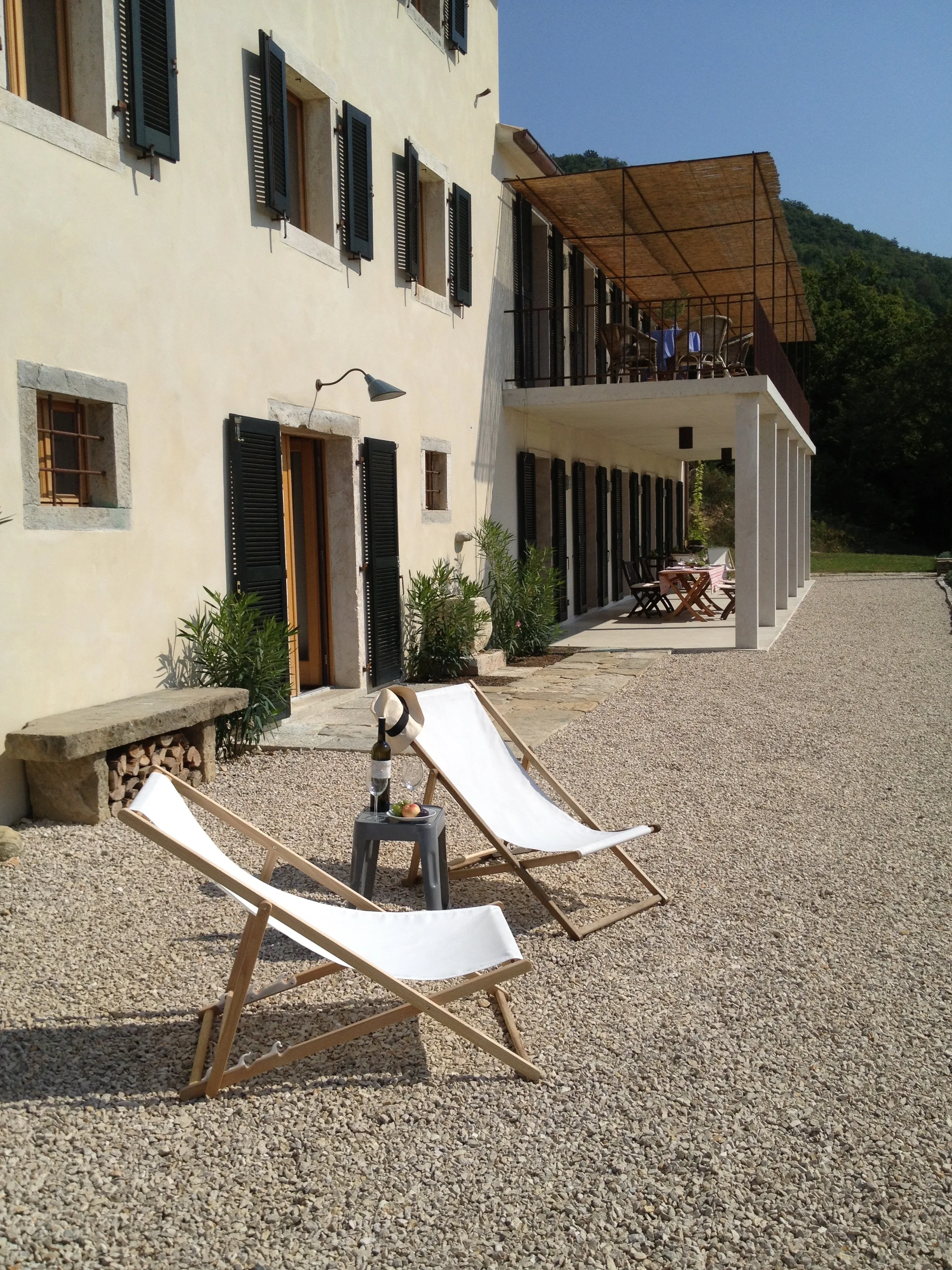 Sunloungers with wine bottle on terrace, house in background