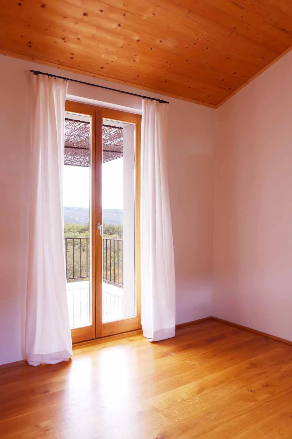 Open living room with original timber beams and polished concrete floor